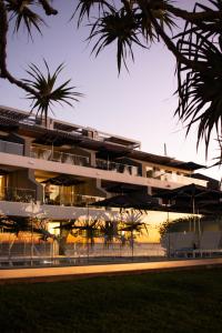 ein Gebäude mit Palmen davor in der Unterkunft Netanya Noosa Beachfront Resort in Noosa Heads