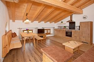 eine große Küche mit Holzboden und einem Tisch in der Unterkunft Thaurerhof Urlaub auf dem Bauernhof in Bernau am Chiemsee