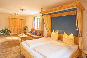 ein Schlafzimmer mit einem großen Bett mit Baldachin in der Unterkunft Thaurerhof Urlaub auf dem Bauernhof in Bernau am Chiemsee