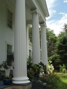 a group of white columns on a house at House of 1833 Bed and Breakfast in Mystic