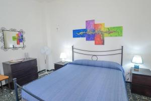 a bedroom with a blue bed and two dressers at Casa Lella - VADOALMARE Immobiliare in Savona