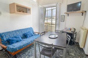 a living room with a blue couch and a table at Casa Lella - VADOALMARE Immobiliare in Savona