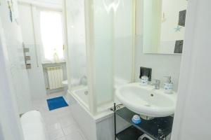 a white bathroom with a sink and a shower at Casa Lella - VADOALMARE Immobiliare in Savona +12 photos