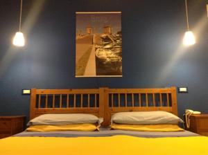 um quarto com uma cama de madeira e 2 almofadas amarelas em B&B Ciliegio Felice em Molinella