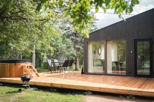 una piccola casa nera con terrazza in legno di Paluküla tiny house Kuuse a Paluküla