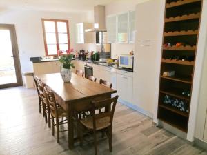 a kitchen with a wooden table and chairs in a kitchen at Maison de charme pour huit à neuf personnes proche Sarlat et vallée de la Dordogne au calme in Vitrac