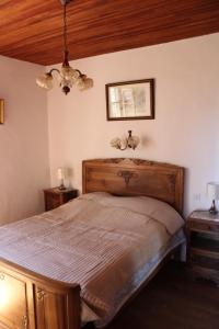 una camera con letto in legno e 2 comodini di Authentique ferme périgourdine, à 5km au sud de Sarlat, 1km de la rivière a Vitrac