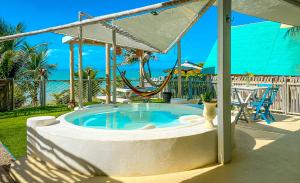 a hot tub in a backyard with a swing at ASAS DEL MAR - SUITES in Canoa Quebrada