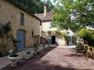 una casa in pietra con un vialetto di fronte di Authentique ferme périgourdine, à 5km au sud de Sarlat, 1km de la rivière a Vitrac