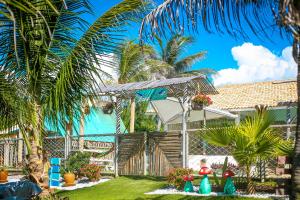 a house with palm trees in the yard at ASAS DEL MAR - SUITES in Canoa Quebrada