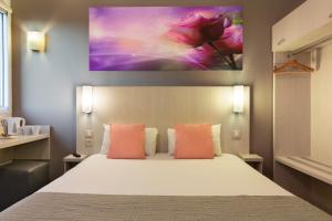 a bedroom with a bed and a painting on the wall at Comfort Hotel Orléans Olivet in Olivet