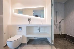a bathroom with a sink and a toilet and a mirror at Limehome Amsterdam Gatwickstraat in Amsterdam