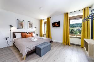 a bedroom with a bed and a large window at VonMos Moselblick Apartments in Kinheim