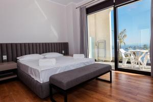 a bedroom with a large bed and a balcony at Villa White Pearl in Palasë +133 photos