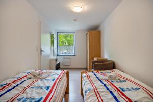 Un dormitorio con dos camas y una ventana. en Bungalow Kay, Bgl 4, en Dranske