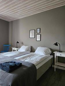 twee bedden in een slaapkamer met twee tafels en twee lampen bij Lilla Älvbrogården i stan in Avesta