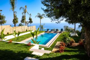 a swimming pool in a yard with the ocean in the background at Villa White Pearl in Palasë
