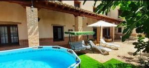 a swimming pool in front of a house at Casa Rural La Era in Aldeanueva de Barbarroya