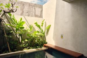a swimming pool with a wooden bench next to a building at Two Thirds Villa Canggu in Canggu