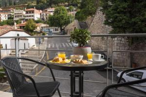 un tavolo con un piatto di cibo su un balcone di THOLOS HOTEL a Delfi