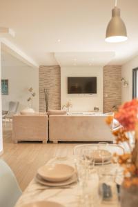 a living room with a couch and a table at Les Villas Chamontines - La Villa des Chênes in Labeaume