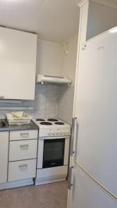 a kitchen with a white stove and a refrigerator at Sackle's place in Pori