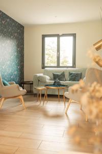 a living room with a couch and a table at Les Villas Chamontines - La Villa des Chênes in Labeaume