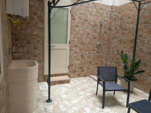 a bathroom with a shower and a chair and a tub at Le tre coccinelle in Porto Cesareo +47 photos