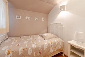 a bedroom with a bed with a bedspread with leaves on it at Les Vespres - Farm House Near Bernex and Thollon les Memises in Saint-Paul-en-Chablais