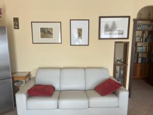 een woonkamer met een witte bank en 2 rode kussens bij Teresa al mare in Montesilvano