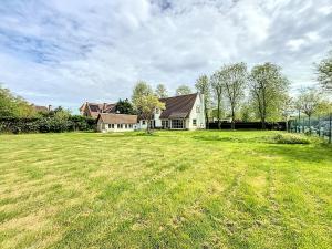 a large grass field with a house in the background at Villa Sunny - Koksijde in Koksijde