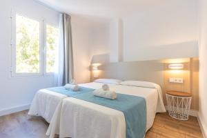 A bed or beds in a room at Apartamentos Massanet