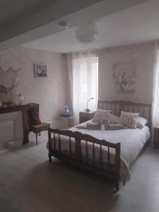 a bedroom with a large bed and a chair at jolie maison dans petit village in Vignory