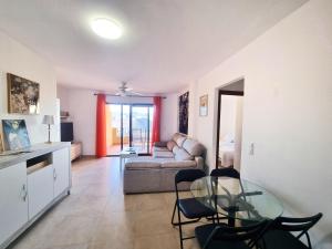 a living room with a glass table and a couch at Apartamento con piscina, urbanización privada by AlohaPalma in Águilas