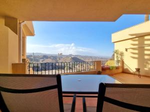 a balcony with a table and a view of the mountains at Apartamento con piscina, urbanización privada by AlohaPalma in Águilas