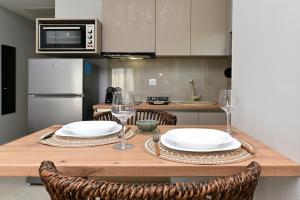 a kitchen with a wooden table with plates and wine glasses at Vista Paraiso Inn in Nea Potidaea