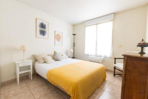 a bedroom with a bed with a yellow blanket on it at Gozzi in Ajaccio