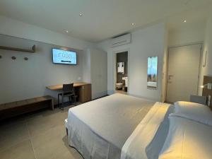 a bedroom with a bed and a desk and a tv at B&B Room47 in Alba Adriatica