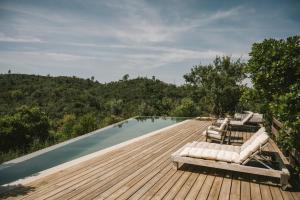 Una piscina con tumbonas en una terraza de madera. en The ONE - Country House, en Grândola