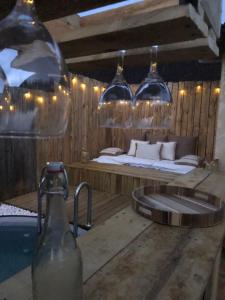 a bathroom with a sink and a bed with wine glasses at La bergerie des petits loups in Montagnac-la-Crempse