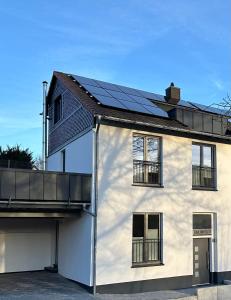 Casa blanca con paneles solares en el techo en FeWo Seetraum, en Diemelsee