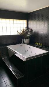 a bath tub in a black bathroom with a plant at Villa a Hovås con molti comfort in Hovås