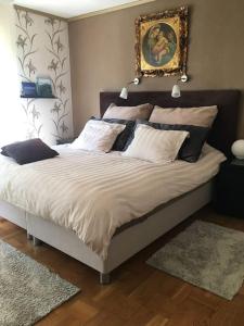 a bedroom with a large bed with white sheets and pillows at Villa a Hovås con molti comfort in Hovås