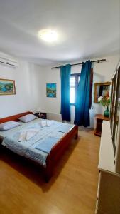 a bedroom with a large bed with blue curtains at Joković Accommodation in Kotor