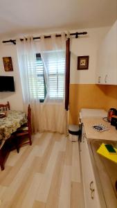 a room with a kitchen with a table and a window at Joković Accommodation in Kotor