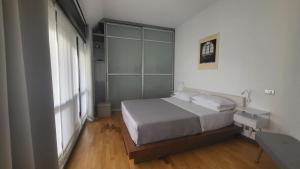 um quarto com uma cama e uma grande janela em San Siro Terrace Attic Apartment Milano em Milão