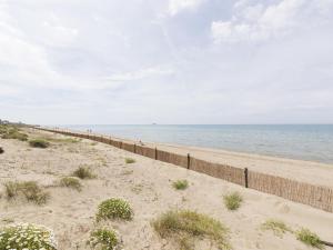 una playa de arena con una valla y el océano en Apartment Rome's Beach House 1 by Interhome, en Torvaianica