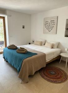 una camera da letto con un letto grande con asciugamani sopra di Feliz Lagartija a Cala Saona