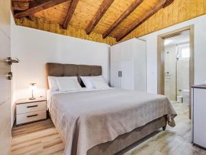 a bedroom with a large bed and a wooden ceiling at Holiday Home Villa Frane by Interhome in Maslenica