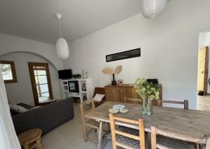 un soggiorno con un tavolo e un divano di Feliz Lagartija a Cala Saona